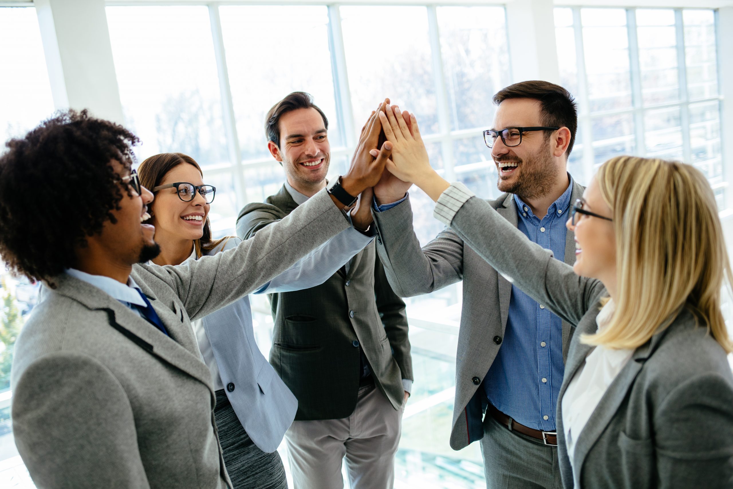 Excited business team give high five celebrate corporate success